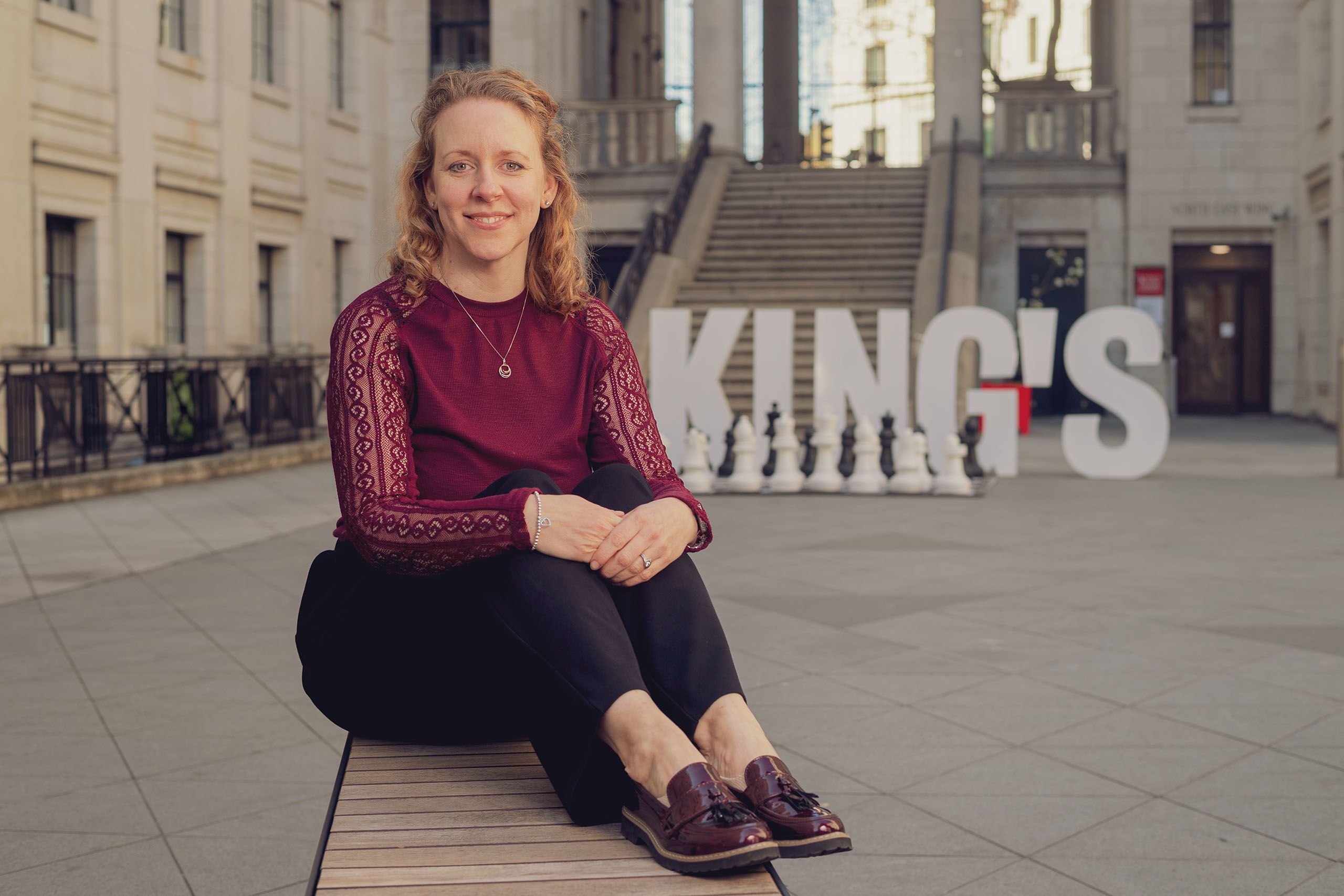 Emma Keith is pictured smiling whilst sat in the Bush House Quad.