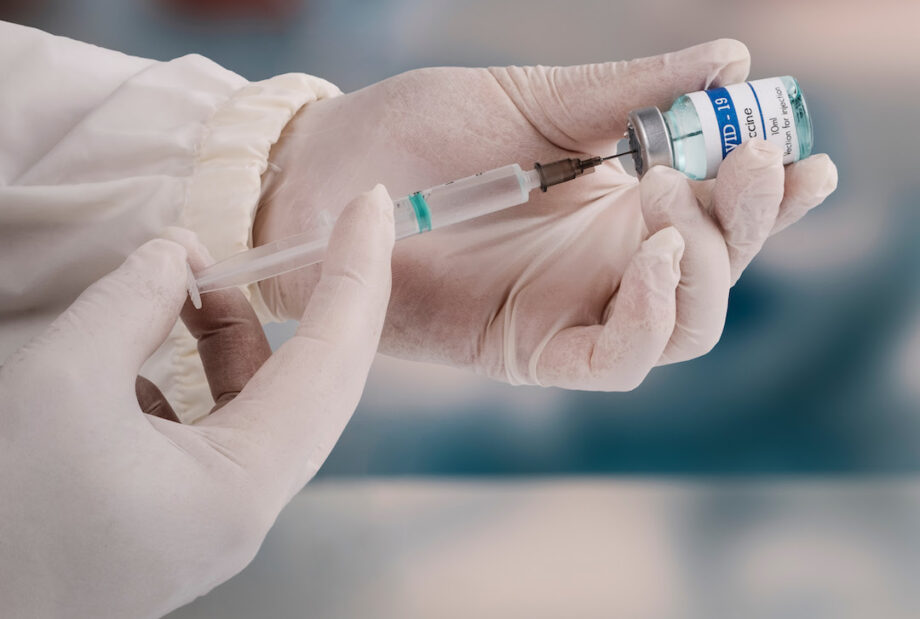Filling a syringe from small vaccine bottle.